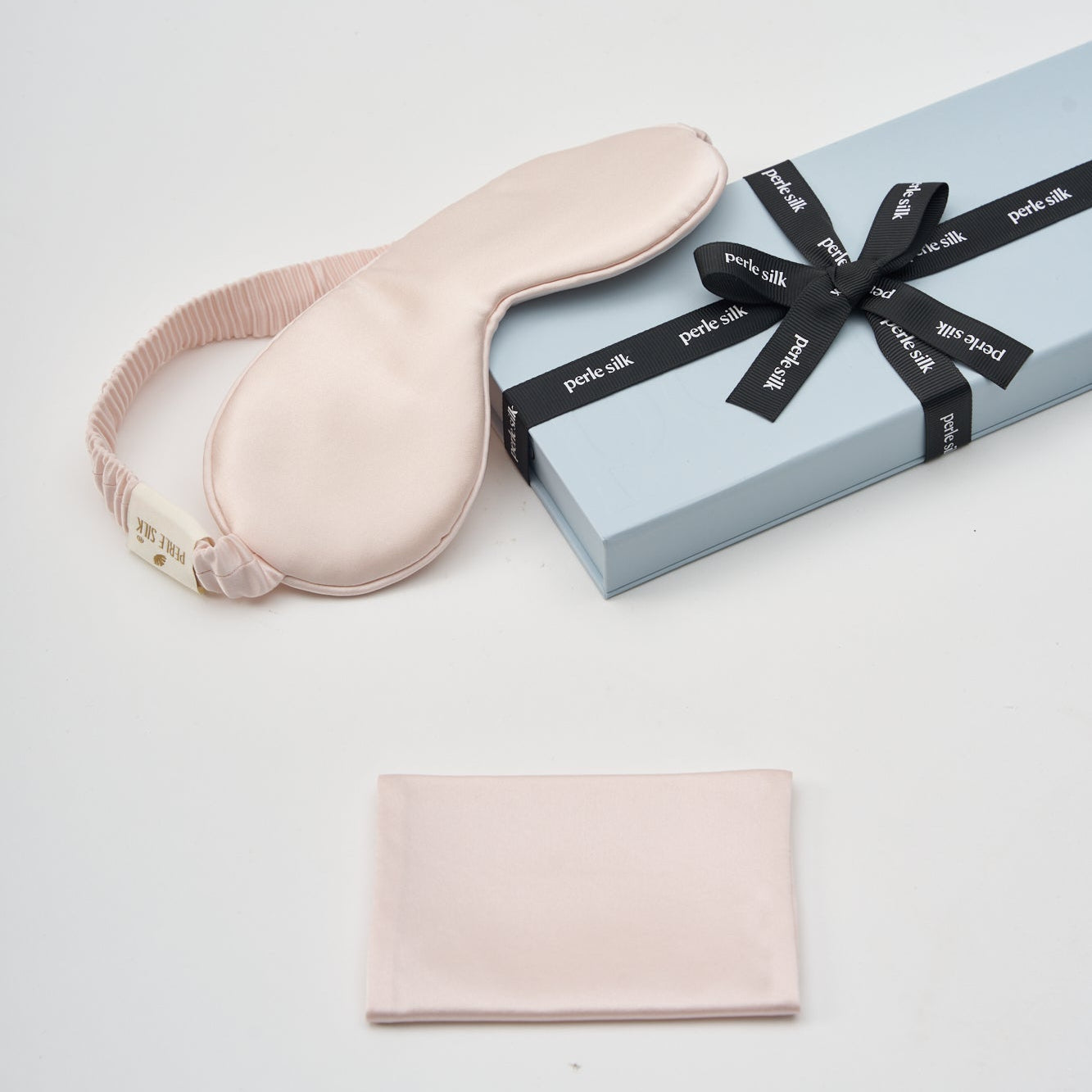 Pink eye mask and pouch with a gift box on a white background